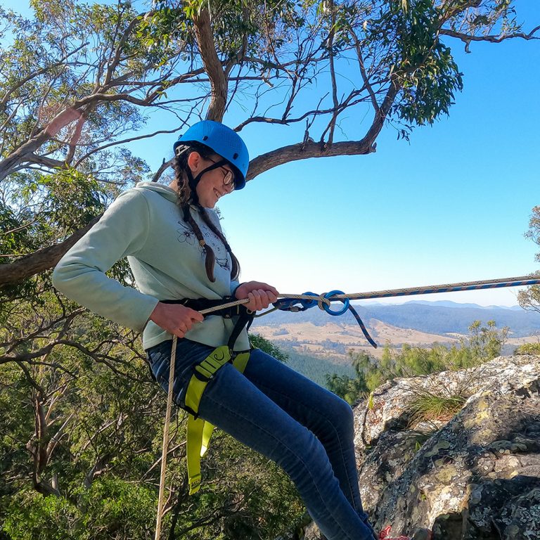Faith Christian School of Distance Education student abseiling off a rocky mountain at Point Pure Lookout on camp