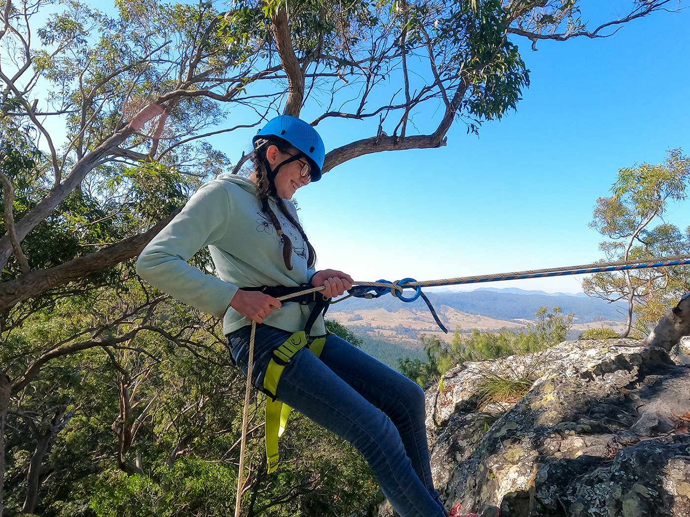 Faith Christian School of Distance Education student abseiling off a rocky mountain at Point Pure Lookout on camp